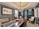 Elegant dining room with a large wooden table, stylish chandelier, and views into the living room at 127 Bradshaw Park Dr, Woodstock, GA 30188