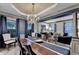 Elegant dining room with a large wooden table, stylish chandelier, and views into the living room at 127 Bradshaw Park Dr, Woodstock, GA 30188