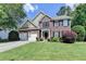 Charming two-story brick home with a well-manicured lawn, two-car garage, and beautifully landscaped front yard at 127 Bradshaw Park Dr, Woodstock, GA 30188