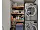 Efficient laundry setup with stacked machines and shelving for organized storage at 127 Bradshaw Park Dr, Woodstock, GA 30188