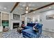 Inviting living room with a fireplace, beamed ceilings, and a blue sectional sofa at 127 Bradshaw Park Dr, Woodstock, GA 30188