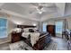 Spacious main bedroom showcasing a decorative rug, tray ceiling, and natural light from several windows at 127 Bradshaw Park Dr, Woodstock, GA 30188