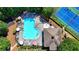 Aerial view of community pool, tennis courts, and outdoor seating, surrounded by mature trees and lush landscaping at 127 Bradshaw Park Dr, Woodstock, GA 30188