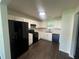 Kitchen featuring white cabinets, black appliances, granite countertops, and modern flooring at 131 Turning Point, Stockbridge, GA 30281