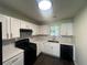Kitchen featuring white cabinets, black appliances, granite countertops, and modern flooring at 131 Turning Point, Stockbridge, GA 30281