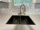 Modern kitchen sink with updated gold fixtures, quartz countertops, and stylish backsplash at 131 Turning Point, Stockbridge, GA 30281