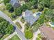 Overhead shot of a grey roof home with a in-ground pool, landscaped gardens, and a long driveway at 3090 Creek Tree Lane, Cumming, GA 30041