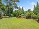 Expansive backyard featuring lush green lawn, mature trees, and a sparkling pool, perfect for outdoor recreation at 3090 Creek Tree Lane, Cumming, GA 30041