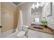 A convenient bathroom featuring tile surround, granite countertop vanity, and well-lit mirror at 3090 Creek Tree Lane, Cumming, GA 30041