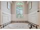 A decorative soaking tub beneath a stained glass arched window at 3090 Creek Tree Lane, Cumming, GA 30041