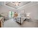 Comfortable bedroom boasting tray ceilings, a writing desk, and a large window with natural light at 3090 Creek Tree Lane, Cumming, GA 30041