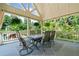 Inviting covered patio with dining set, overhead lights, and views of the lush greenery, perfect for outdoor gatherings at 3090 Creek Tree Lane, Cumming, GA 30041