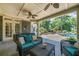 Relaxing covered patio with wicker furniture overlooking the lush backyard and sparkling pool at 3090 Creek Tree Lane, Cumming, GA 30041