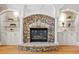 Living room fireplace made of stone with custom built-in shelving and cabinets on either side at 3090 Creek Tree Lane, Cumming, GA 30041