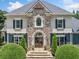 Charming front entrance features a stone facade, double doors, and manicured shrubbery adding to the home's appeal at 3090 Creek Tree Lane, Cumming, GA 30041
