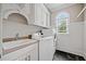 Bright laundry room featuring white cabinetry and countertop with washing machine and dryer at 3090 Creek Tree Lane, Cumming, GA 30041
