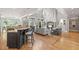 Open-concept living area showing a stone fireplace, hardwood floors, and access to the kitchen at 3090 Creek Tree Lane, Cumming, GA 30041
