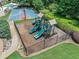 The fenced-in community playground features multiple slides, play structures and is surrounded by greenery at 3090 Creek Tree Lane, Cumming, GA 30041