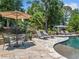 Poolside seating area with umbrella-covered table and lounge chairs, perfect for outdoor relaxation and entertainment at 3090 Creek Tree Lane, Cumming, GA 30041