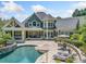 Inviting backyard featuring a sparkling pool, patio with lounge furniture, and a covered porch for outdoor entertaining at 3090 Creek Tree Lane, Cumming, GA 30041