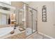 Corner of the bathroom featuring a glass shower, tile surround, and soaking tub with candles at 11715 Dancliff Trce, Alpharetta, GA 30009