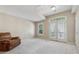 Bedroom with an chair, large windows, French doors, and neutral walls offer a relaxing space at 11715 Dancliff Trce, Alpharetta, GA 30009