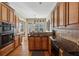 A kitchen with wood cabinets, granite countertops, and stainless steel appliances provide ample cooking space at 11715 Dancliff Trce, Alpharetta, GA 30009