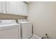 Laundry room featuring side by side appliances and upper cabinets at 11715 Dancliff Trce, Alpharetta, GA 30009