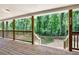 View from the covered back porch showing wooden floors, railings, and wooded backyard at 257 Martin Ln, Canton, GA 30114