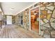 Covered back porch with stone wall, ceiling fan, and view to open-concept kitchen/living area at 257 Martin Ln, Canton, GA 30114