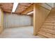 Unfinished basement featuring concrete walls, exposed ceiling with insulation, and wooden stairs at 257 Martin Ln, Canton, GA 30114