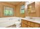 Bathroom features a jacuzzi tub with jets, vanity with wood cabinets and a window with nature views at 257 Martin Ln, Canton, GA 30114