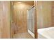 Bathroom with a glass shower, wooden walls and floors, and a small closet for convenient storage at 257 Martin Ln, Canton, GA 30114