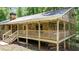 Ranch-style home with a covered wooden porch and stone exterior, with stairs leading up to the entrance at 257 Martin Ln, Canton, GA 30114