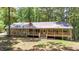Charming ranch-style home with stone facade and a spacious wooden deck, nestled among lush trees at 257 Martin Ln, Canton, GA 30114