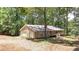 View of the ranch style home featuring stone siding and a two-car garage, surrounded by lush trees at 257 Martin Ln, Canton, GA 30114