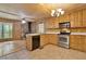 View of kitchen with a stone fireplace in an attached living area with stainless steel appliances and wood cabinets at 257 Martin Ln, Canton, GA 30114