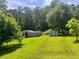 Backyard featuring storage sheds and mature trees offering shade and privacy at 4380 Highway 138, Oxford, GA 30054