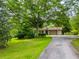 Charming single-story home with mature trees and a long driveway leading to an attached garage at 4380 Highway 138, Oxford, GA 30054