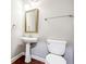 Powder room with pedestal sink, framed mirror, and hardwood floors at 7160 Fawn Lake Dr, Alpharetta, GA 30005