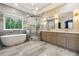 Modern bathroom featuring a soaking tub, glass enclosed shower, and double vanity with stone countertops at 7160 Fawn Lake Dr, Alpharetta, GA 30005