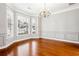 Dining room featuring hardwood floors, large bay windows, chair rail, and elegant chandelier at 7160 Fawn Lake Dr, Alpharetta, GA 30005