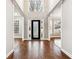 Elegant foyer featuring hardwood floors, wainscoting, decorative door, and views to the living area at 7160 Fawn Lake Dr, Alpharetta, GA 30005