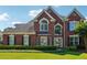 Charming brick home with manicured lawn, lush landscaping, and classic architectural details at 7160 Fawn Lake Dr, Alpharetta, GA 30005
