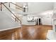 Open-concept living area with hardwood floors, staircase, bar seating, and seamless flow into the kitchen at 7160 Fawn Lake Dr, Alpharetta, GA 30005
