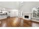 Open-concept living space featuring hardwood floors, fireplace, bar seating, and seamless flow into the kitchen at 7160 Fawn Lake Dr, Alpharetta, GA 30005