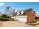 View of the home's rear exterior and driveway, showcasing ample parking space and partial brick siding at 7160 Fawn Lake Dr, Alpharetta, GA 30005
