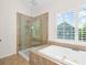 Bright bathroom featuring a shower, and a soaking tub under a window with shutters at 1215 Renaissance Se Ct, Mableton, GA 30126