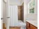 Cozy bathroom featuring a shower and tub combination with brown tile and a window at 1215 Renaissance Se Ct, Mableton, GA 30126