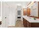 Bright bathroom hallway featuring a vanity with wood cabinets and a mirror, and views of a bedroom at 1215 Renaissance Se Ct, Mableton, GA 30126
